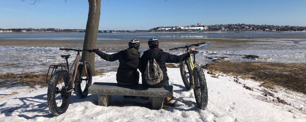 Couple Looking Out at Casco Bay with Fat Bikes in Winter, Photo Provided by Summer Feet Cycling Couple Looking Out at Casco Bay with Fat Bikes in Winter, Photo Provided by Summer Feet Cycling