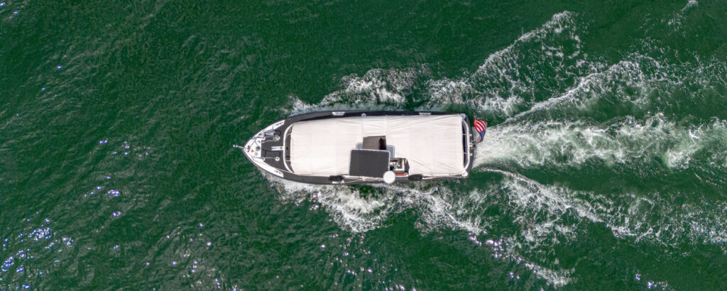Aerial of white boat sailing in green ocean; Photo Credit: Peter G. Morneau Photography Aerial of white boat sailing in green ocean; Photo Credit: Peter G. Morneau Photography