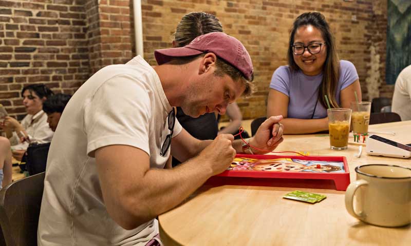 Man concentrating on Operation Game; Photo Credit: Amanda Huebner Photography Man concentrating on Operation Game; Photo Credit: Amanda Huebner Photography